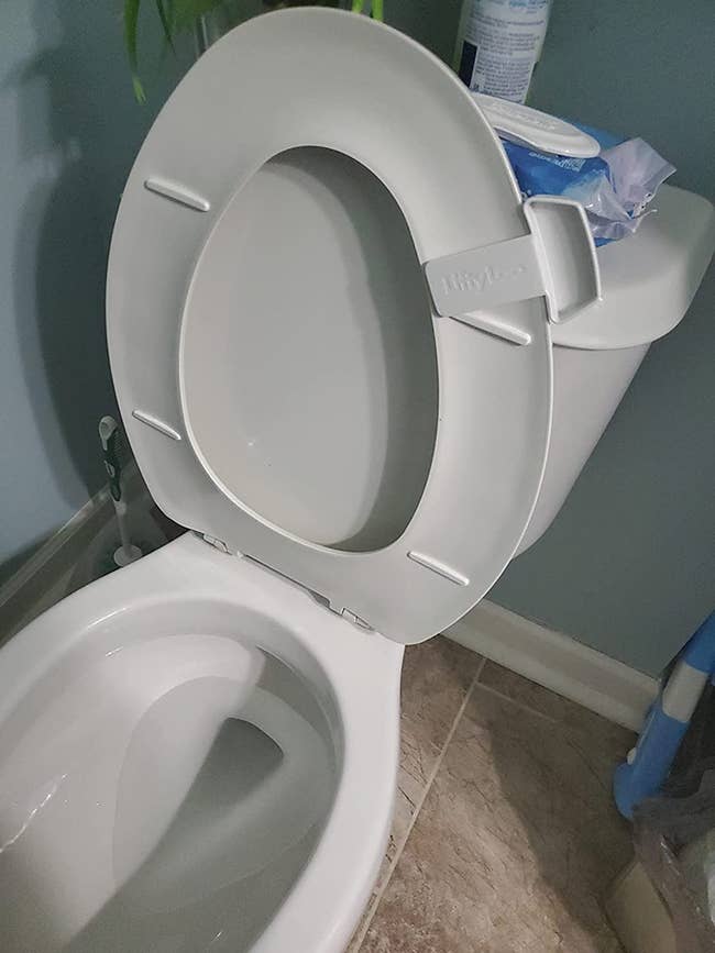 a white toilet seat handle attached to white toilet seat