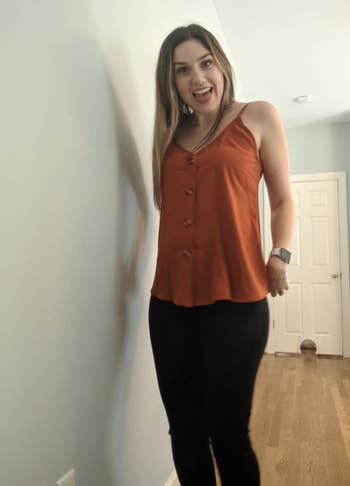 reviewer wearing button down tank in a orange color with black bottoms