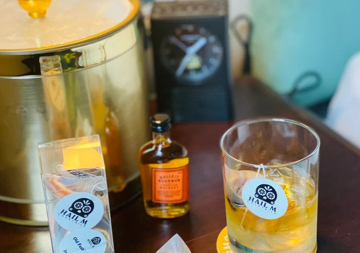 a filled rocks glass with a pack of the infusions sachets sitting next to it