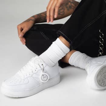 model wearing the all white yums sneakers 