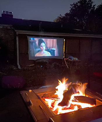 reviewer photo of the screen on the side of a house with a fire pit in the foreground