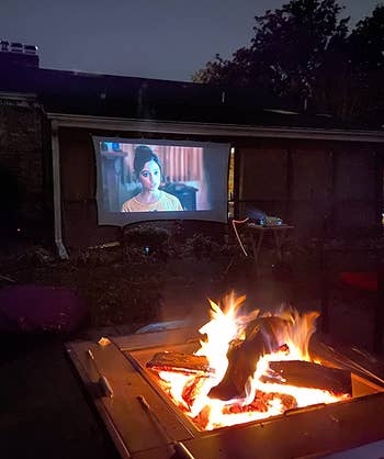 reviewer photo of the screen on the side of a house with a fire pit in the foreground