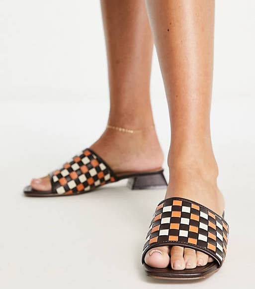 model in very low heel brown white and orange woven checkerboard mule sandals