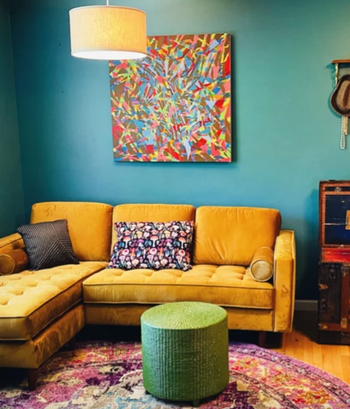 reviewer photo of the couch in yellow in the corner of living room
