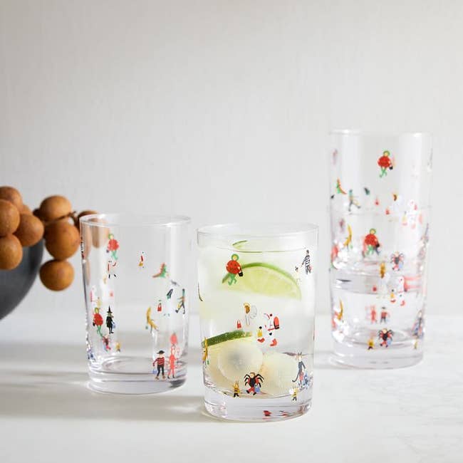 clear drinking glasses with illustrations of people in many different halloween costumes 