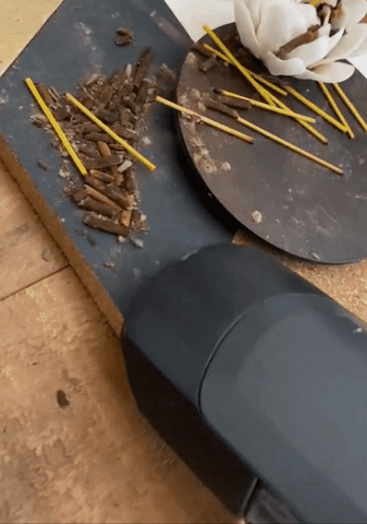 gif of a reviewer using the handheld vac to suck up incense debris