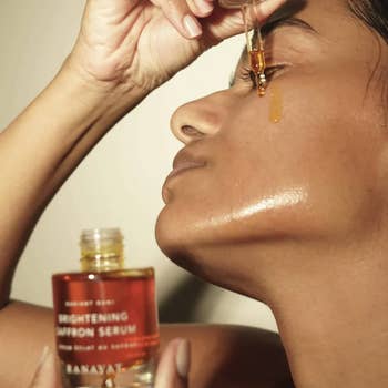 a model putting drops of the serum on their face