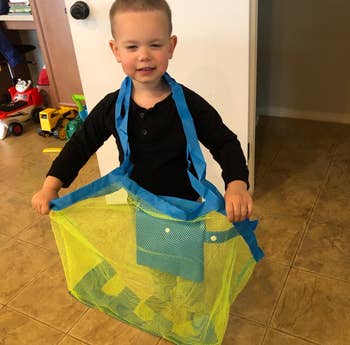 reviewer's photo of a child holding the bag with toys inside