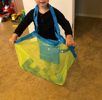 reviewer's photo of a child holding the bag with toys inside