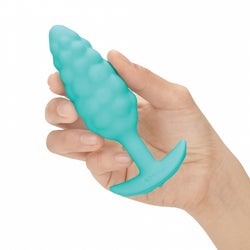 Model holding small butt plug textured with bumps