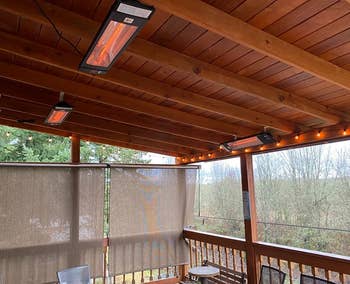 Three heaters hung up on the ceiling of a reviewer's covered deck