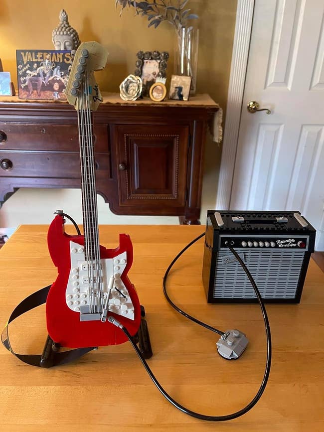 Red Lego Fender guitar connected to a small Lego amplifier