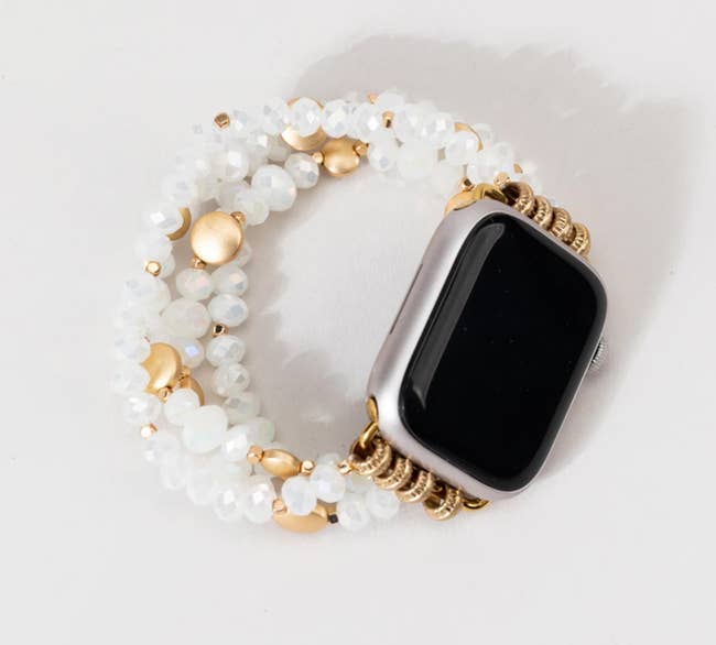 clear and gold bead bracelet hooked to apple watch face