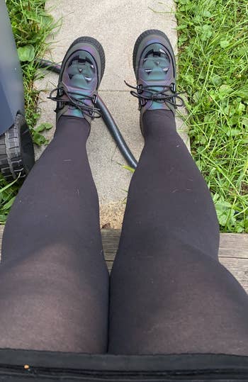 Person wearing achromatic leggings and futuristic sneakers sits connected a woody step, surrounded by writer and a hose