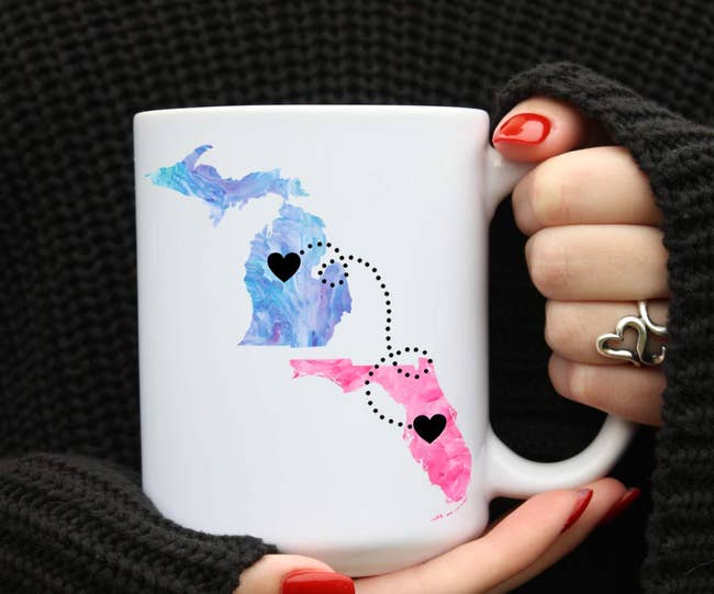 Two hearts printed on different states on a mug that have a dotted line connected them 