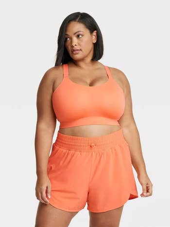 model wearing the orange sports bra