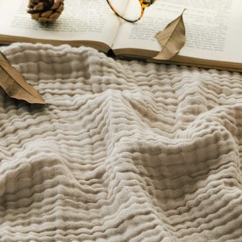 a soft white muslin throw blanket close up, showing the texture