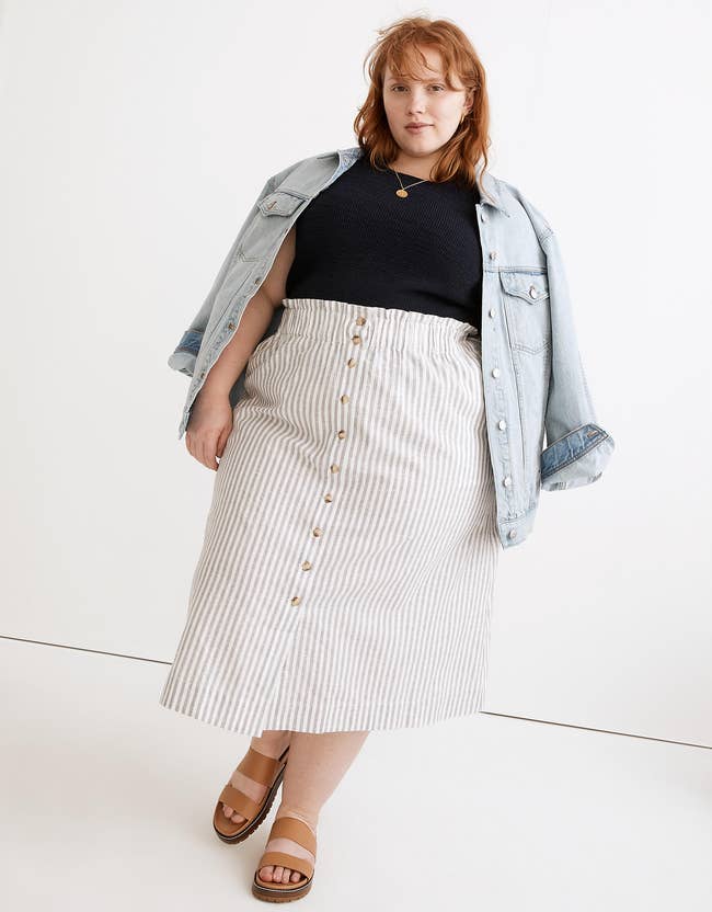 a model in a pin strip midi skirt with buttons down the middle