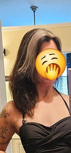 Person successful a bath reflector wearing a stylish achromatic apical with tattooed arm, covering look playfully with an emoji