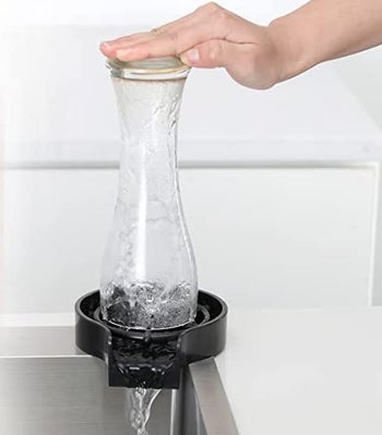 model using it to wash a beer glass
