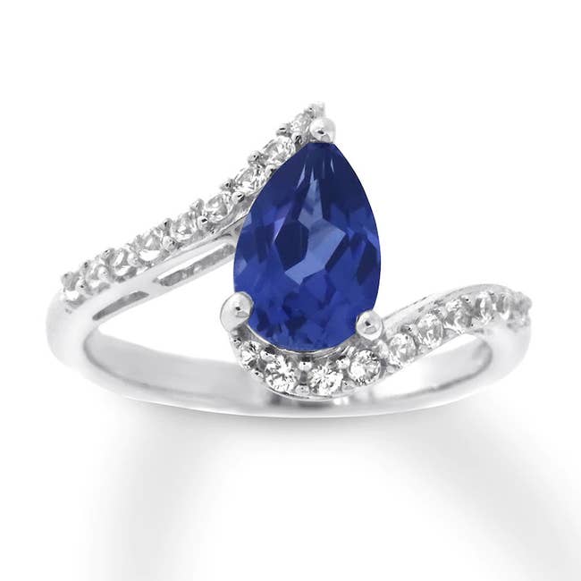 the tear drop ring featuring a blue sapphire and diamonds along the side 