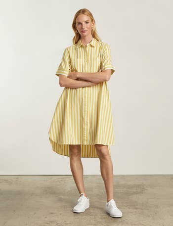 model wearing the yellow and white striped shirtdress with white tennis shoes