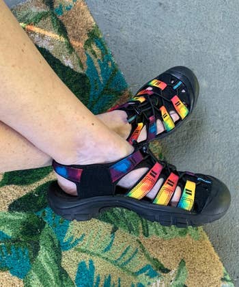 reviewer wearing the water shoes with a rainbow pattern on the stripes