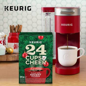 a red single serve keurig with a 24 cups of cheer advent calendar