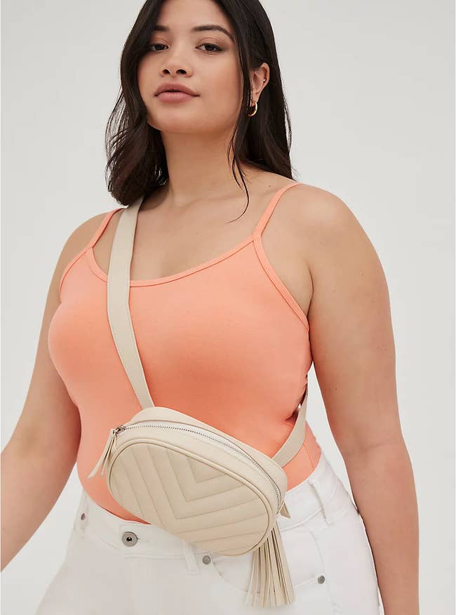 model wears small white belt bag across waist