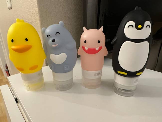 Four cute character-themed reusable bottles displayed on a surface for shopping