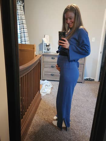 Person successful  a cozy country   takes a reflector  selfie, smiling and holding their belly successful  a stylish, comfy  outfit suitable for maternity wear