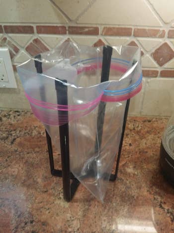 black four prong stand holding plastic bag open