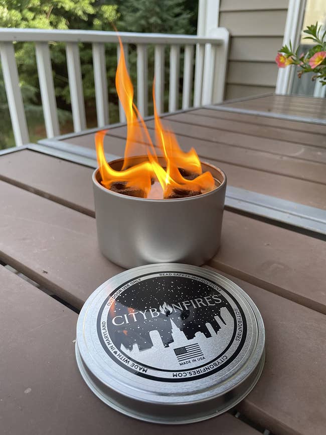 Portable fire pit lit on a table with the label 