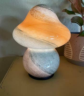 reviewer's mushroom shaped lamp in white with bright colors streaked throughout 
