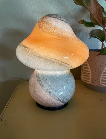 Mushroom shaped lamp in white with bright colors streaked throughout 