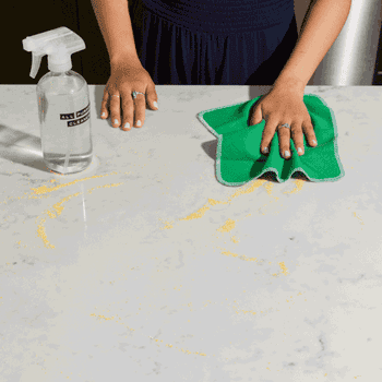 a gif of a model cleaning their counter with a green cloth