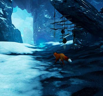 a screenshot from the game showing a. fox walking through a snowy landscape 