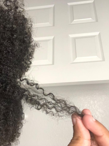 a reviewer with curly hair showing results from mask treatment