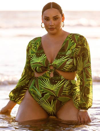 model in green and brown print one piece swimsuit with voluminous sleeves