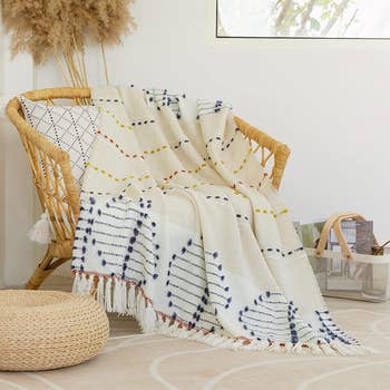 lightweight throw blanket with colorful tassels on wicker chair