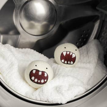 Laundry dryer balls with cartoon monster faces successful  a washing machine, resting connected  a achromatic  towel