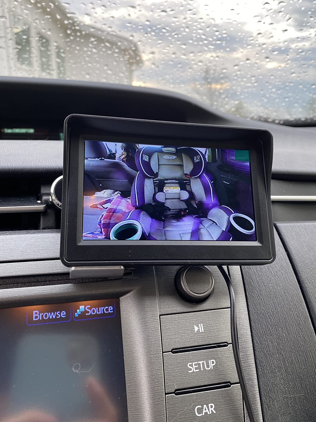 reviewer image of the screen attached to the dashboard of their car with a view of the carseat