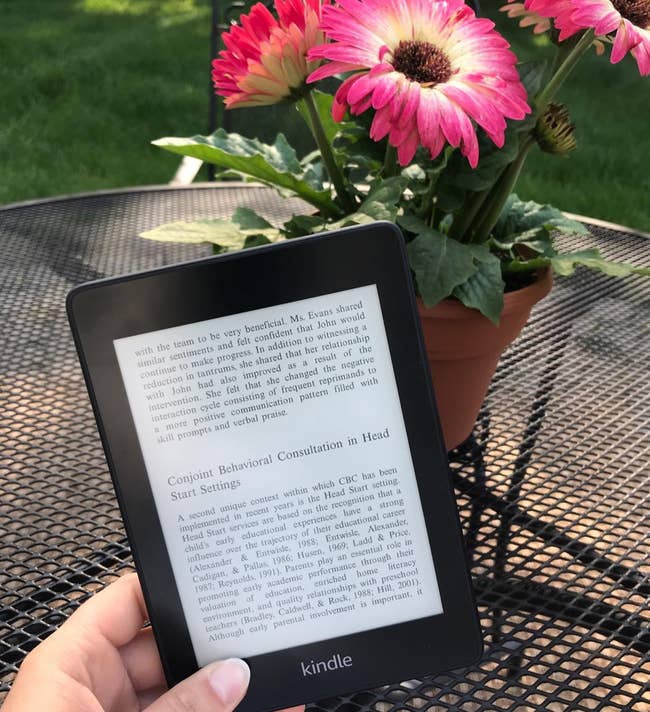 reviewer holding the small Kindle e-reader