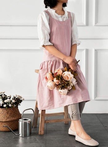 Model in a light pink apron with a slightly ruffled drop skirt 