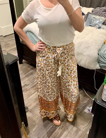 reviewer mirror selfie wearing yellow and white floral palazzo pants