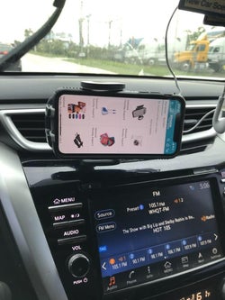 the phone holder attached to a car vent holding a phone that is in landscape mode rotation