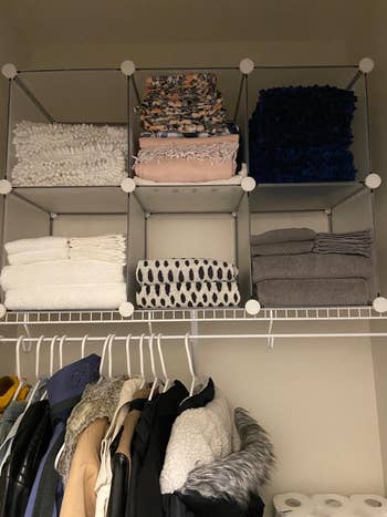 Reviewer image of clear box-shaped storage shelving on top of their closet rack