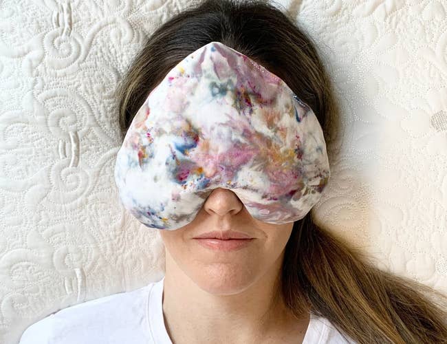 model wearing the heart-shaped pillow over their eyes