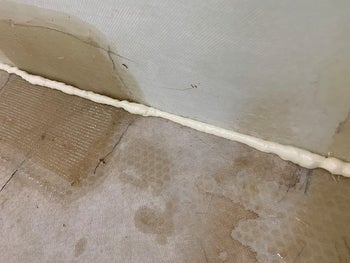 reviewer image of the foam sealant sealing the gap between wall and floor