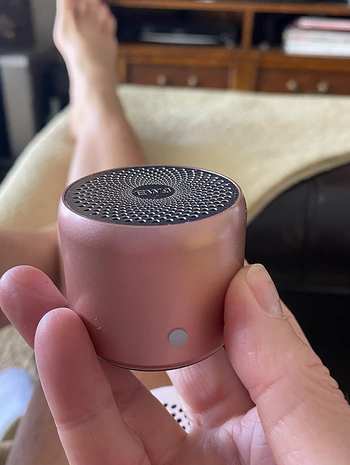 reviewer holding the pink speaker